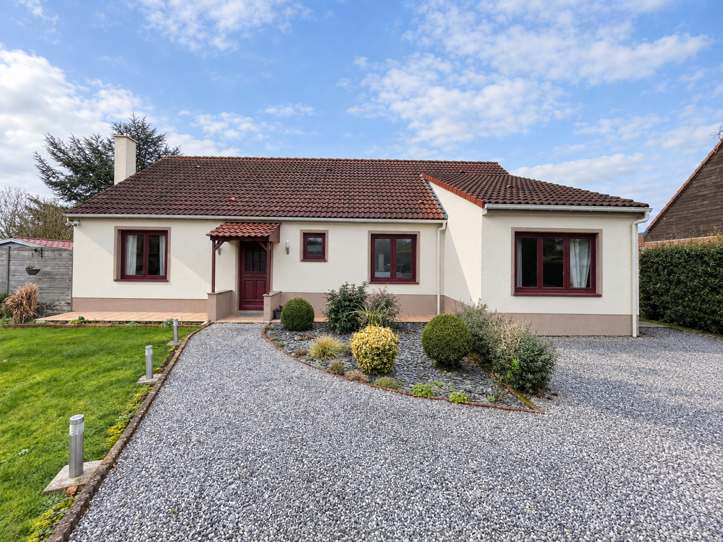 Maison de plain-pied avec fenêtres et porte PVC bordeaux