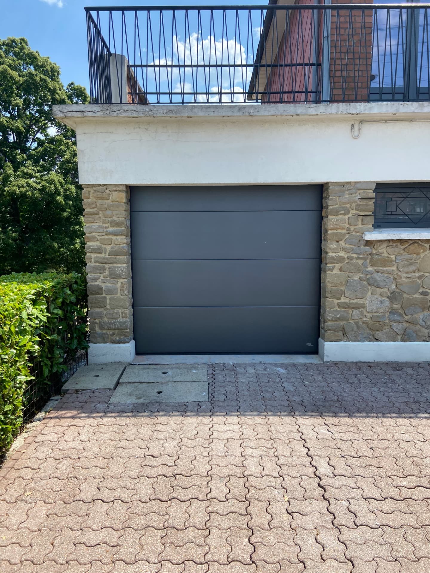 Porte de garage anthracite sur maison en pierre
