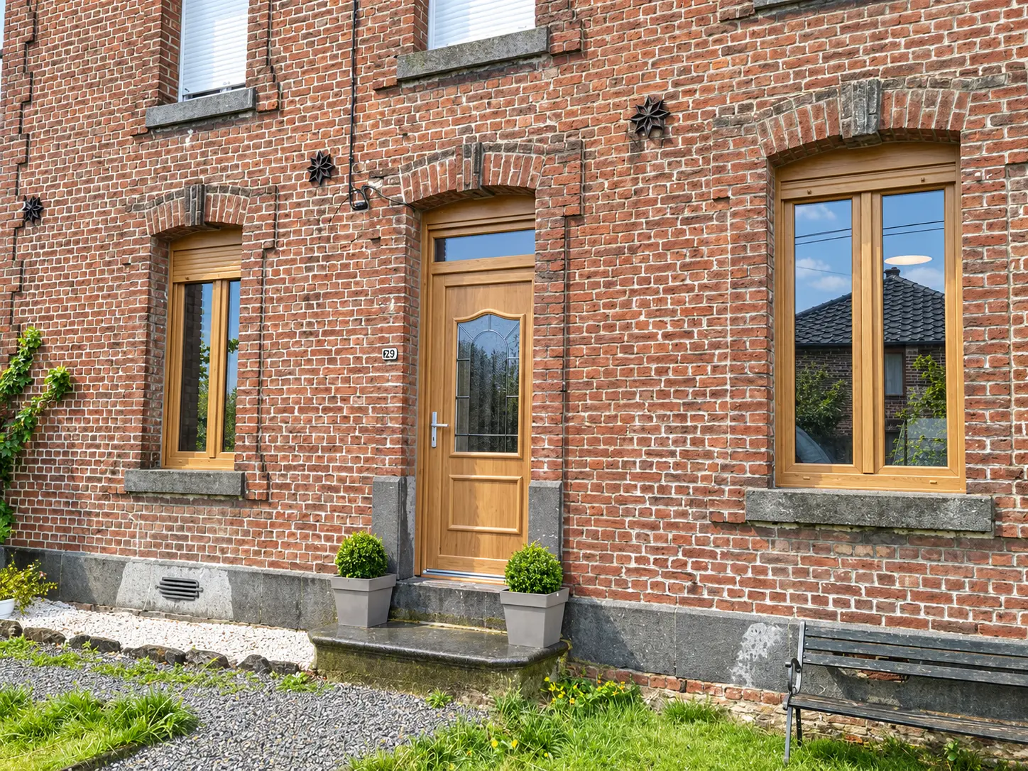 Maison en brique avec fenêtres et porte d'entrée bois effet chêne