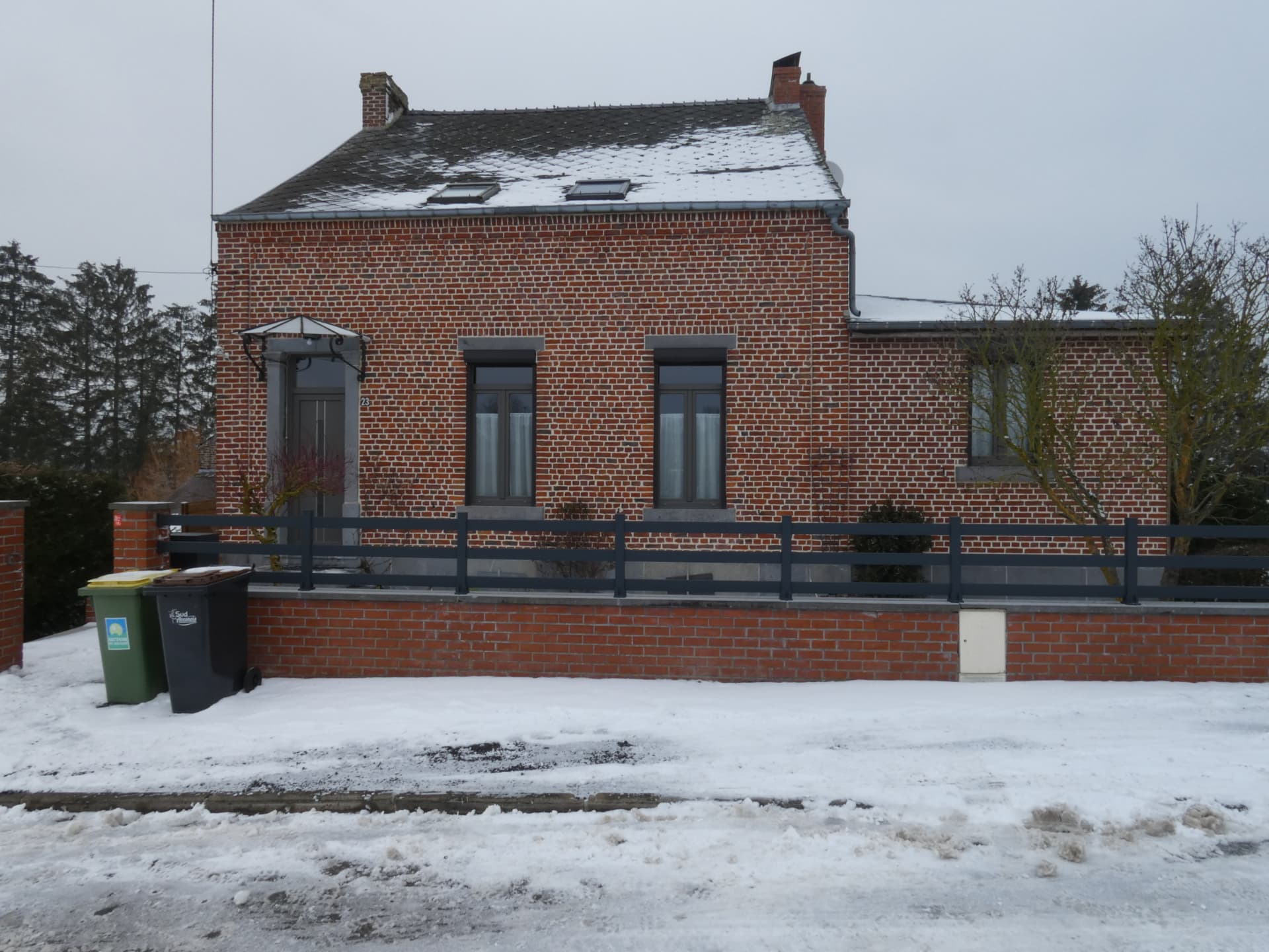 Maison en brique avec fenêtres PVC anthracite et volets motorisés