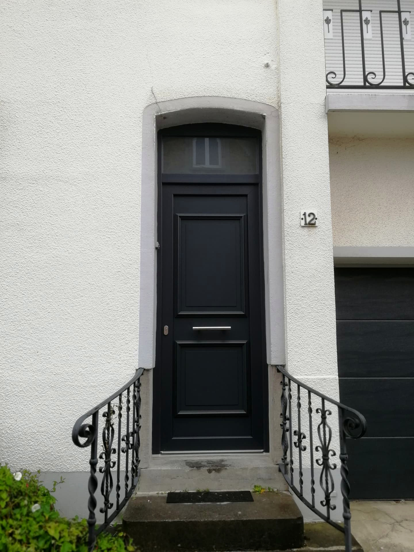 Réalisation VITREC d'une porte d'entrée noire pleine de style classique avec imposte vitrée