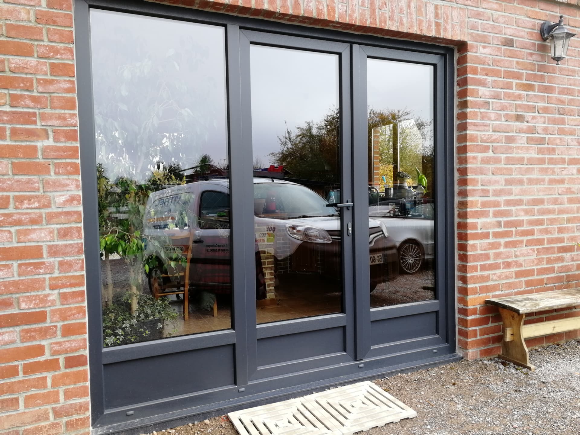 Porte-fenêtre aluminium anthracite sur façade brique