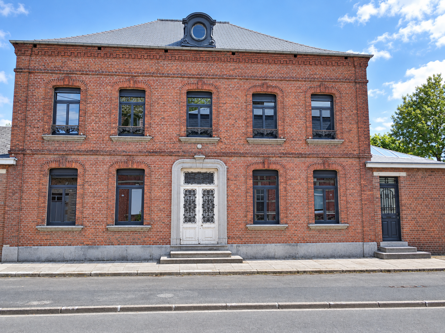 Maison de maître en brique avec fenêtres cintrées anthracite