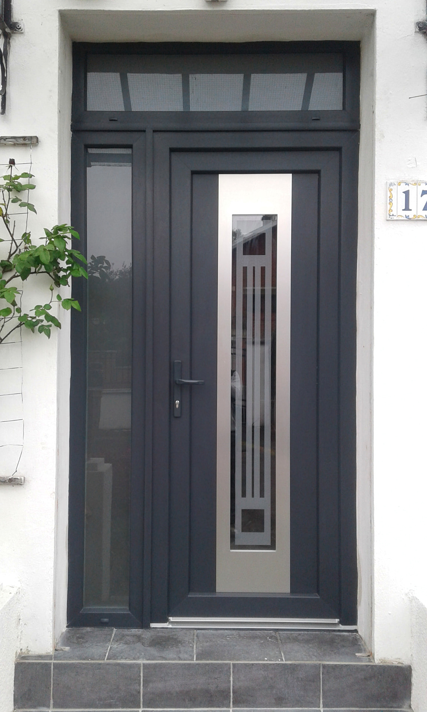 Réalisation VITREC d'une porte d'entrée anthracite avec fixe latéral, imposte et décor inox vertical