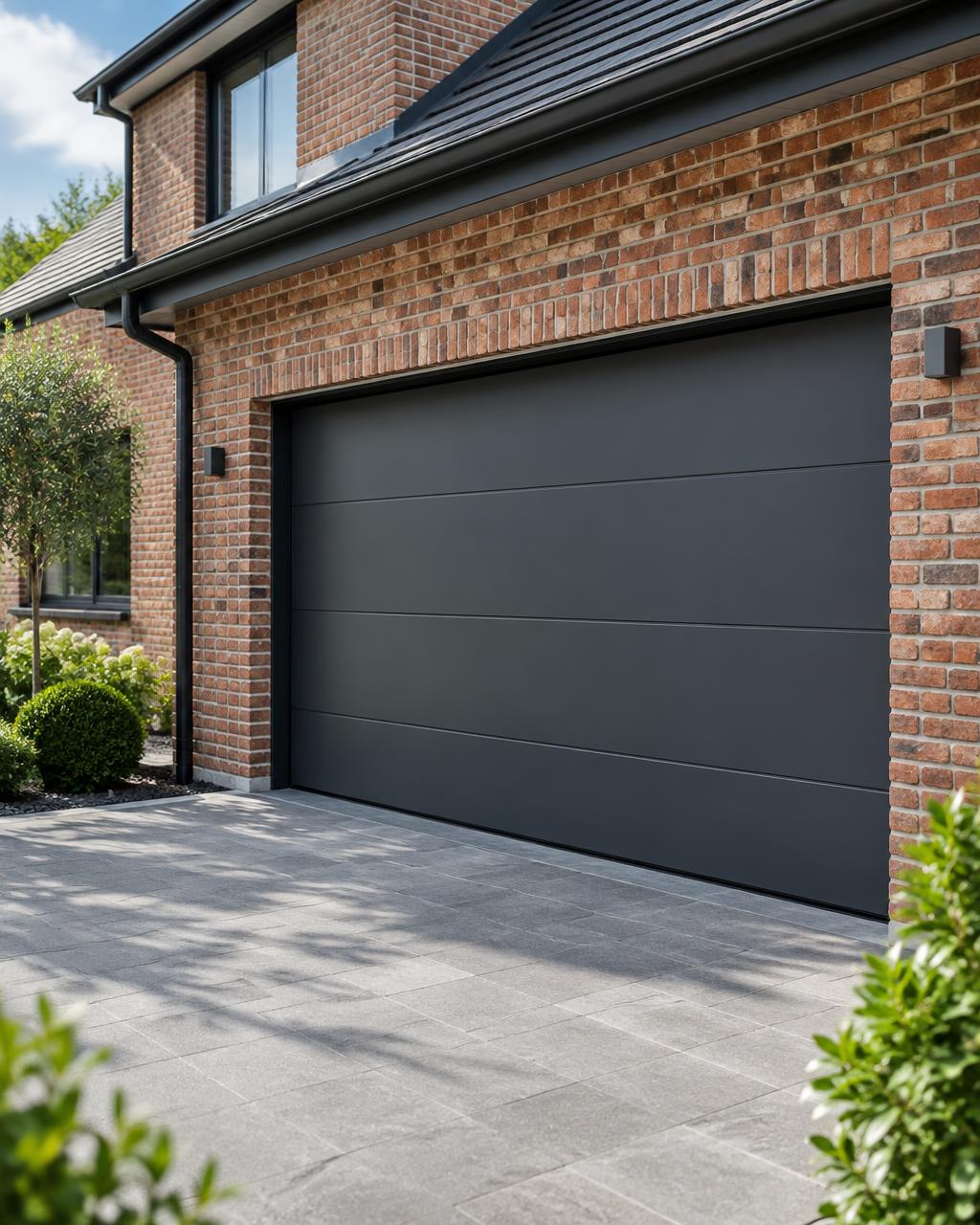 Porte de garage sectionnelle anthracite sur une maison en briques